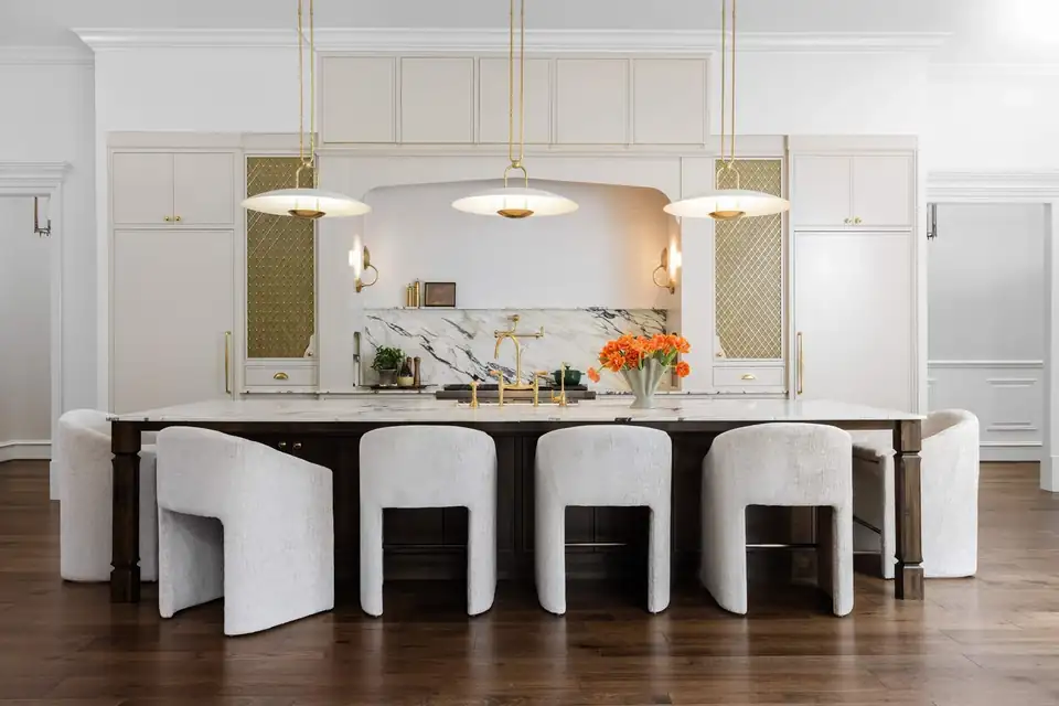 Kitchen remodeling Homewood design-build firm ELM Construction: Indian Springs kitchen with a long dark wood island, white upholstered stools, brass pendants and an arched range hood