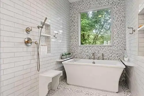 Vestavia primary bathroom wet room with freestanding tub, white brick tile, mosaic accent wall and handheld shower